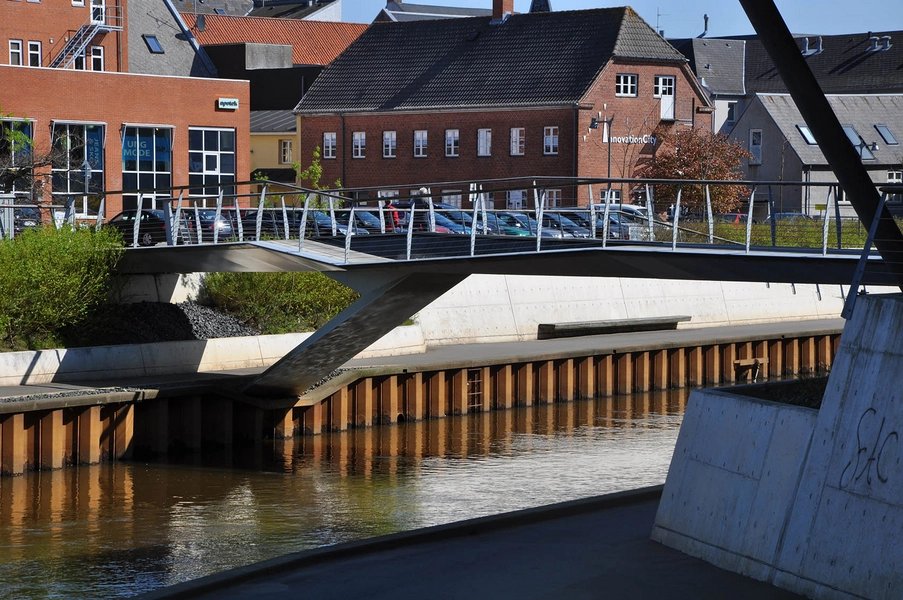 Musikteateret Holstebro Bygningen anslutter til den anden side af Storåen via en dynamisk udformet bro