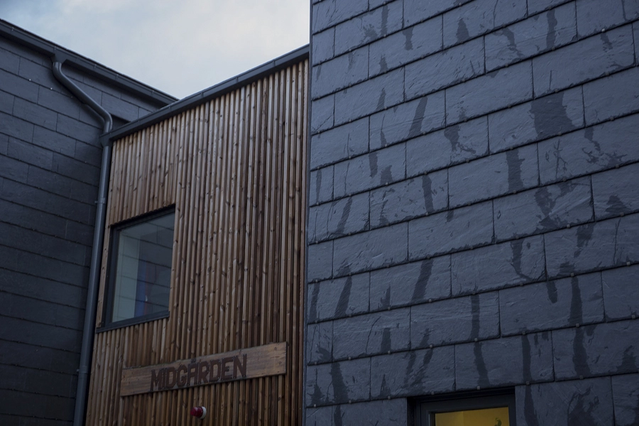 Daginstitutionen Midgården Entrébyginngen i træ fungerer som bindeled mellem de to "villaer" med skiferfacader