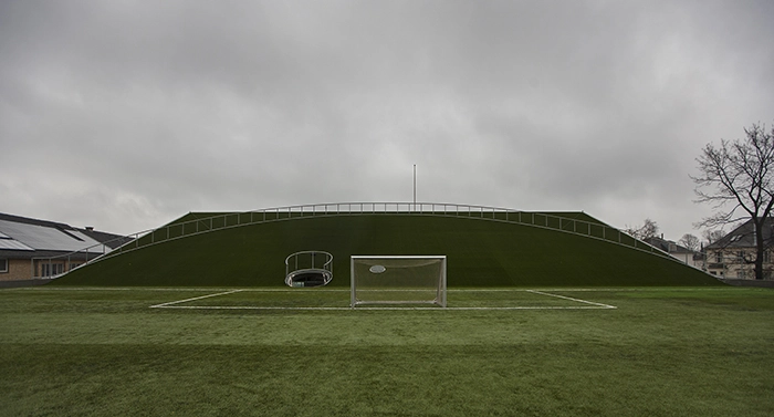 GHG2 Kunstgræsbane med bygningens tag der fungerer som tilskuerpladser