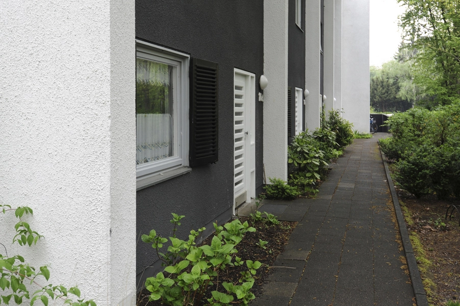 Haus Fisker Østfacade i den lave del med køkkenvindue og indgangsdør.