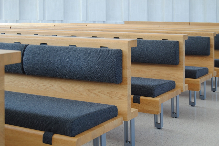 Helligtrekongers Kirke Kirkebænkene af egetræ med polstrede hynder i gråmeleret Hallingdal